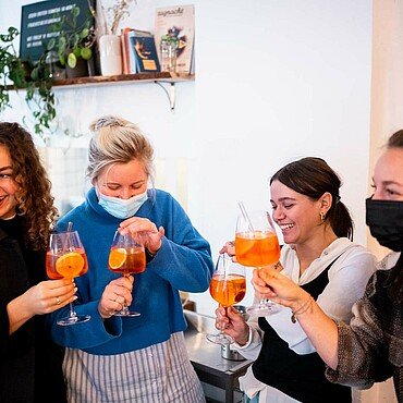 Inhaberin Miriam Caspers stößt mit ihren Mitarbeiterinnen an im Café Walter in der Südstadt