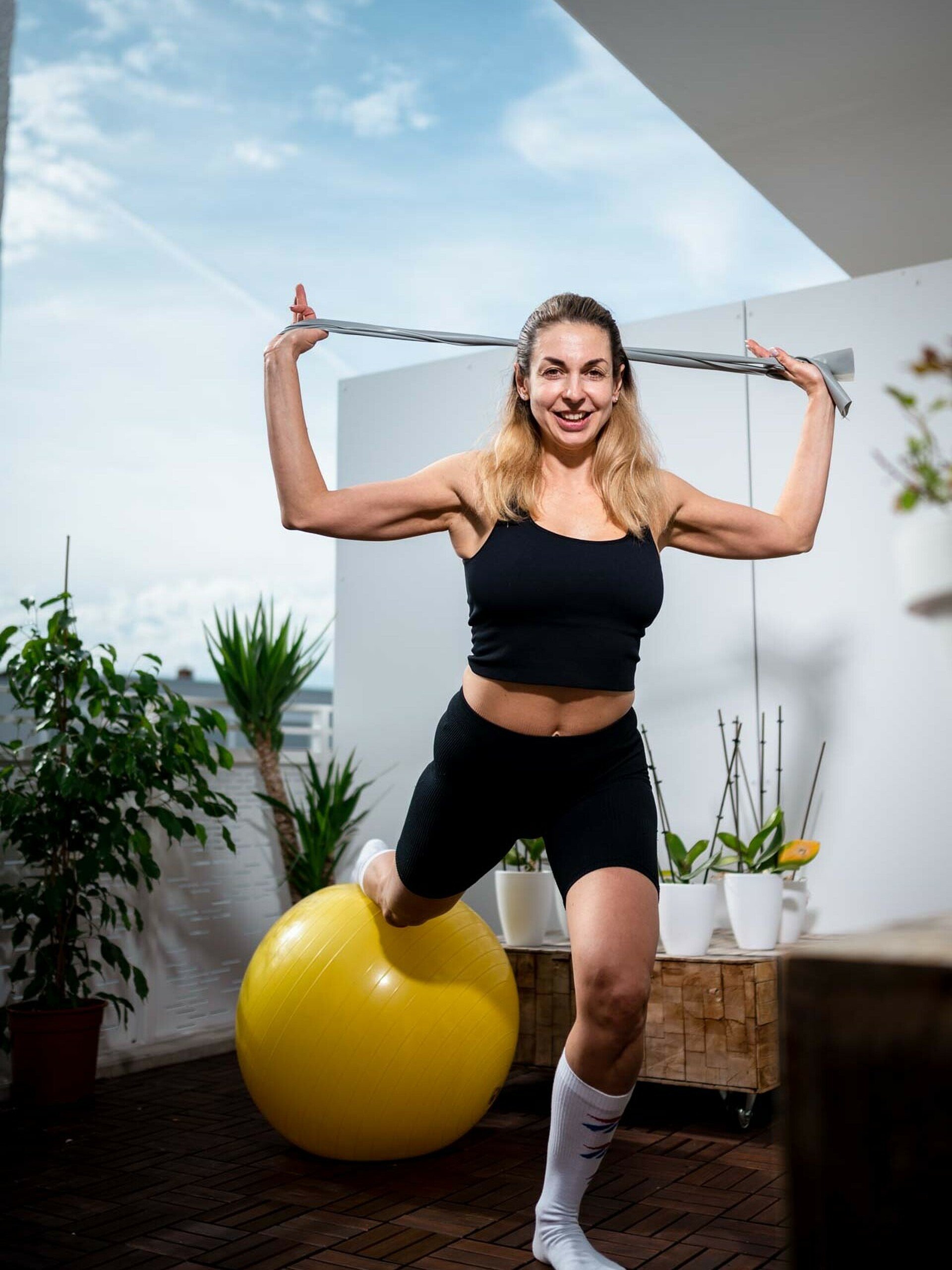 Liliia Lypivska macht eine Balance-Übung auf dem Balkon ihrer Wohnung in Köln-Bickendorf