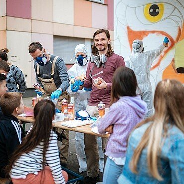 Künstler Matthias Furch erklärt den Kindern den Umgang mit Spraydosen