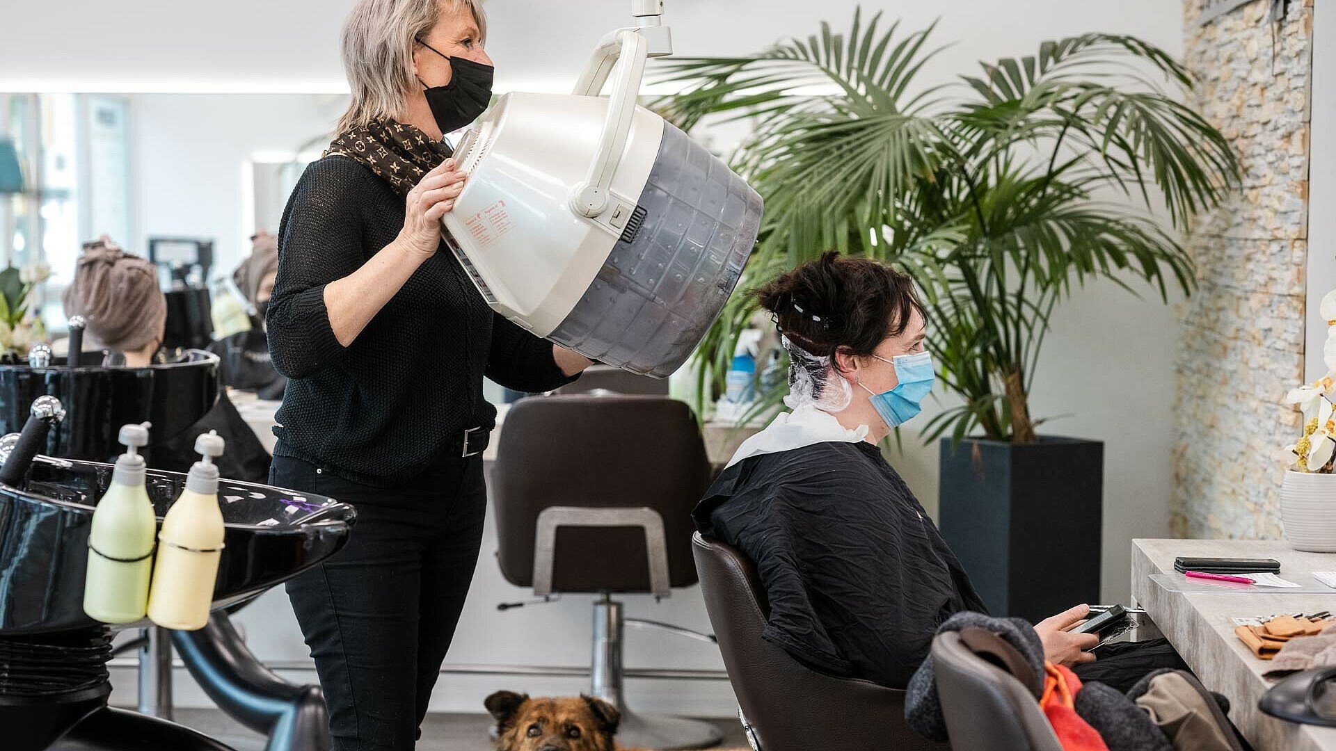 Petra Keßler setzt einer Kundin im Friseursalon „Vivida Nuances“ in Bocklemünd die Trockenhaube auf