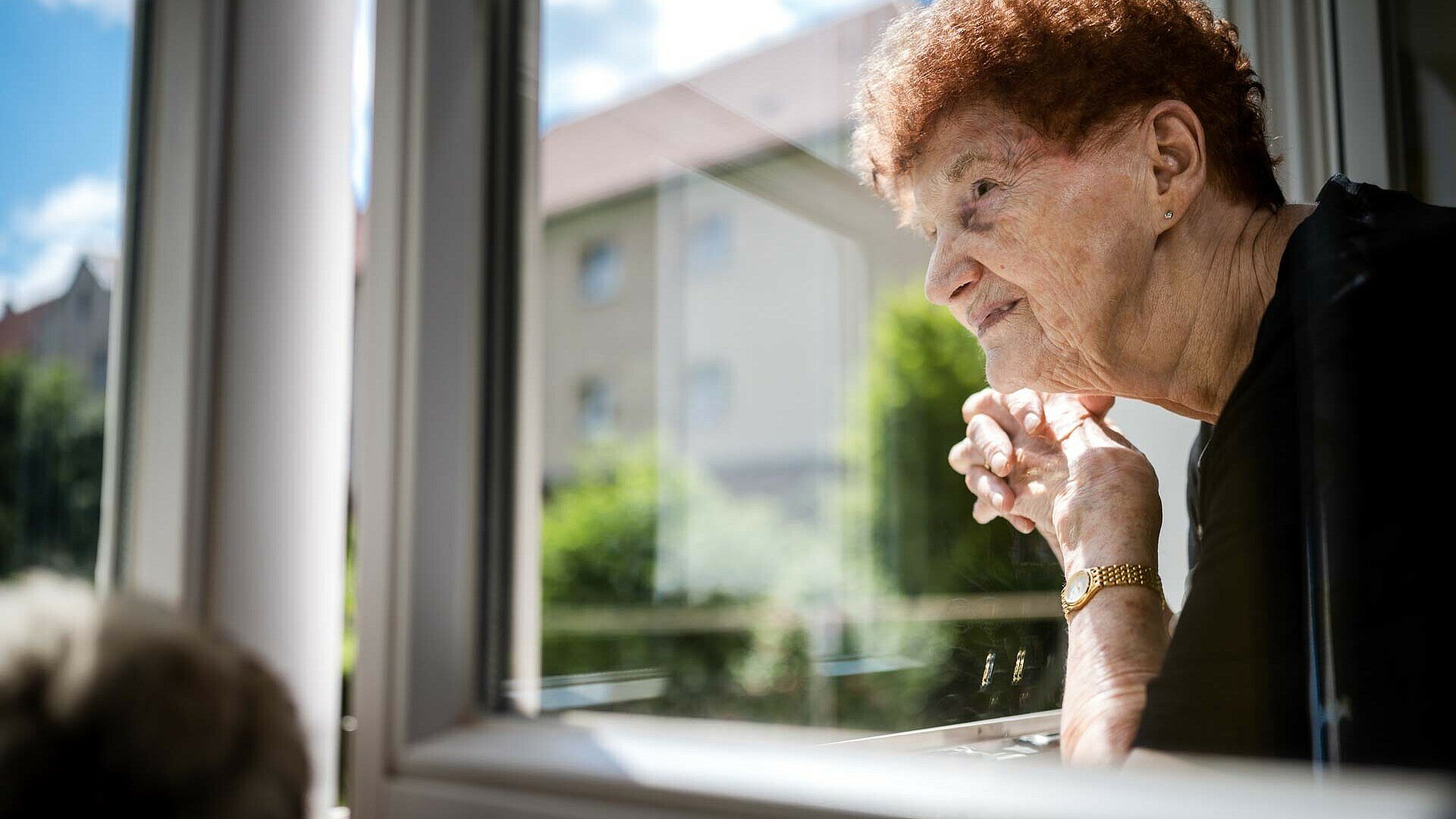 GAG-Mieterin Anneliese Diederich schaut aus dem Fenster ihrer Wohnung in der Germaniasiedlung in Höhenberg