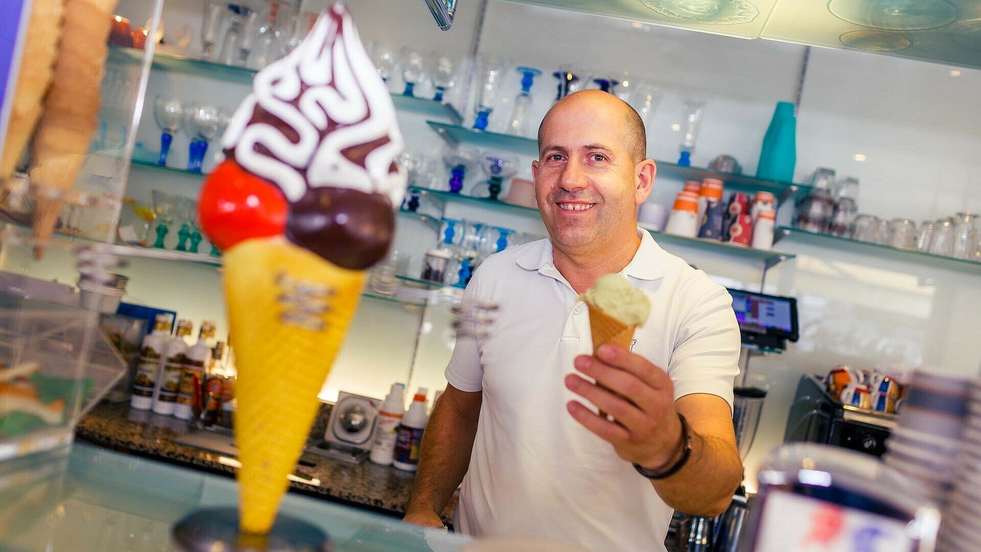 Robert Berisha präsentiert eine Waffel mit Eis im Eiscafé Orchidea in Zollstock