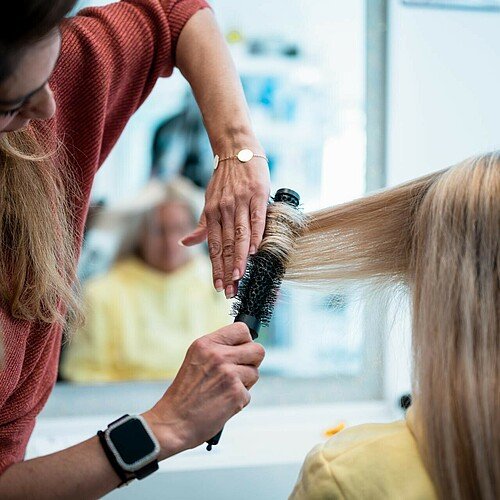 Inhaberin Nuran Altinok frisiert die Haare einer Kundin im Friseursalon Coiffeur Nora in der Kölner Südtstadt