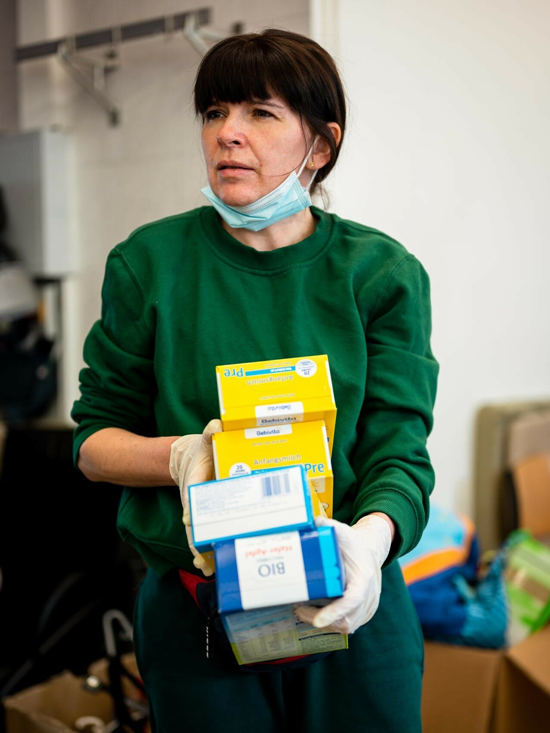 Eine Ehrenamtliche Helferin sortiert Gegenstände in der Sammel- und Ausgabestelle in Chorweiler